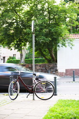 Rower przy ulicy mijany przez samochód