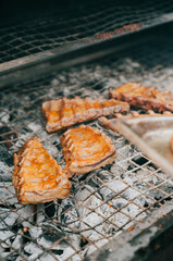 A grill with meat and bread on it