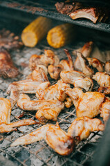 A rack of chicken wings are being cooked on a grill