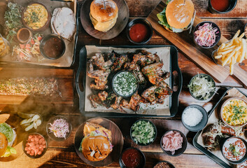 A table full of food including a plate of chicken wings, a plate of fries