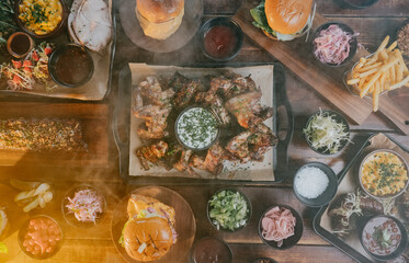 A table full of food including a plate of chicken wings, a plate of fries