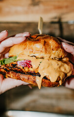 A person is holding a sandwich with a sauce on it