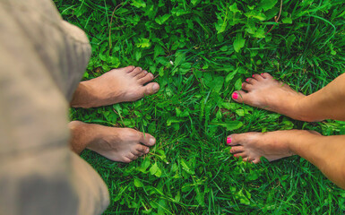 Legs of a woman and a man on the grass. Selective focus.