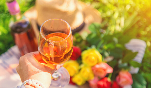 Wine flowers picnic in the garden woman. Selective focus.