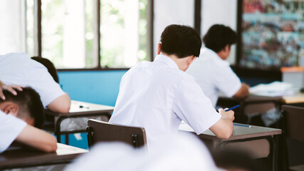 Assessment examination of high school students dressed in uniform.The students were doing the exams inside the classroom with stress