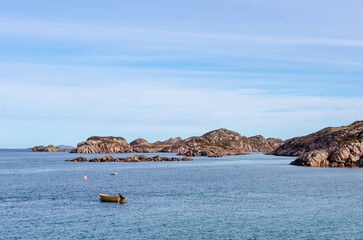 Rocky islands and turquoise waters off the coast of the Isle of Mull under bright blue skies, showcasing the rugged beauty of the Inner Hebrides.