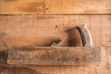 Antique construction tools, such as an old wooden level, a wooden plane, pliers, and a plumb line,...