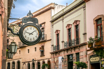 Colorful street in Querétaro with antique clock and traditional Mexican buildings