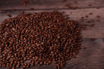 richly textured roasted coffee beans scattered across a warm, rustic wooden surface, evoking an aromatic essence and cozy ambiance with a palette of deep browns and intricate wood grain patterns