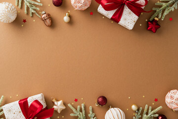 Christmas flat lay with wrapped gifts, red ribbon, baubles, pine branches, and golden stars framing...
