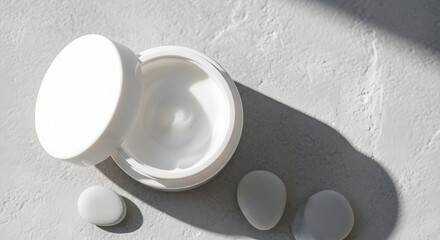 Close-up of a moisturizing cream jar placed on a light gray stone-textured background, top view, soft shadows, simple composition emphasizing product freshness and purity.