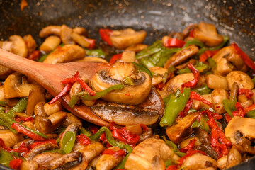 fried cultivated mushrooms with fresh vegetables in a pan for a healthy dinner meal