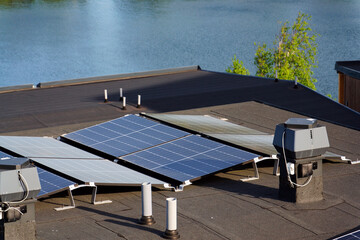Solar panels on roof of apartment housing building, renewable green sustainable energy concept,...