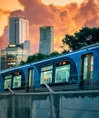 Urban Train at Sunset with City Skyline