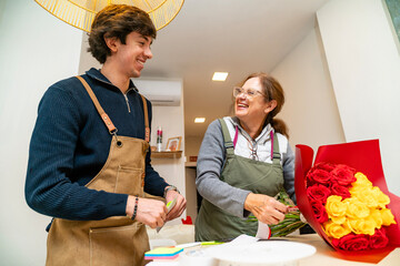 Florist colleagues collaborating creating a beautiful rose bouquet