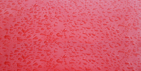 Water drops on a flat red surface
