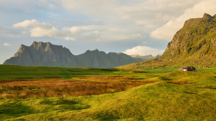 Misty Lofoten valley after rain with soft sunlight and dramatic mountain peaks