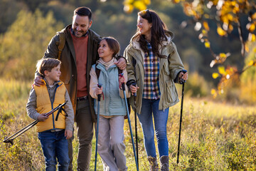 Family enjoys hiking together in a serene nature in autumn