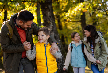 Family enjoys hiking together in a serene forest in autumn
