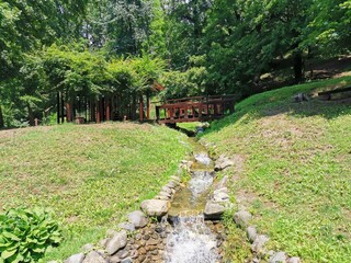 Wooden pavilion and stream in green park