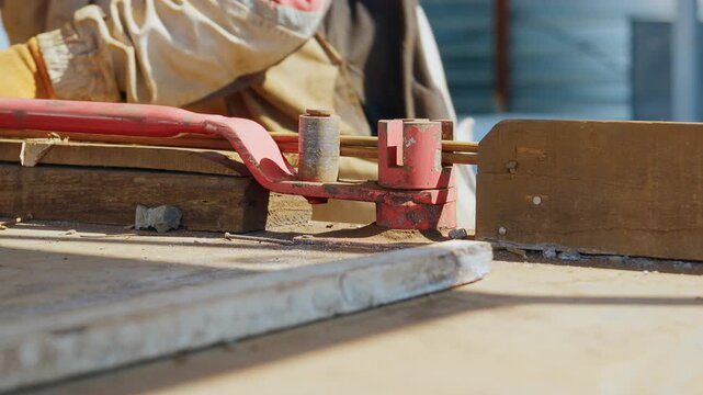 Manual rebar bending with a lever bender at a construction site