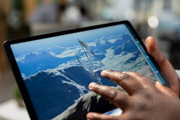 Close up of technician using touchscreen tablet to evaluate next generation wind turbine boosting green energy output. Product designer develops cutting edge vertical axis wind turbine using device