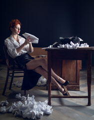 red-haired Woman Writer in a Dramatic Setting with Vintage Typewriter and Crumpled Papers