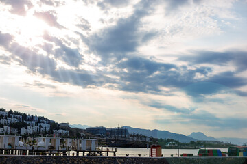 Wooden Pier with White Loungers Over the Sea Turkey. Well-designed wooden pier extends into calm sea, with white loungers and national flags, evoking peaceful holiday setting.