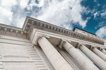 Classical stone facade with tall columns under a blue sky in Washington, D.C. Elegant neoclassical architecture captured in downtown.