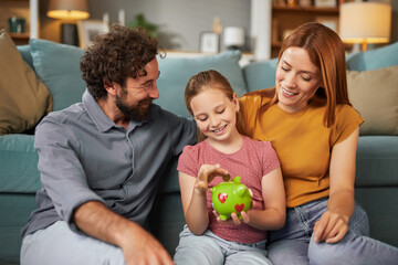 Parents and their daughter sit on a comfortable sofa, engaging joyfully as she plays with a piggy bank, learning the value of saving in a warm and inviting living space.