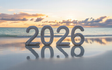 Year 2026 on a sandy beach at sunset reflecting in the wet sand symbolizing the upcoming new year