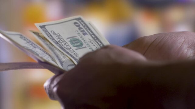 US money counted in hands of a peron. Close-up shot. Salary payment and employment concepts