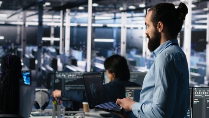 Server room technician using AI LLM chatbot to review infrastructure diagnostics. IT expert in data center using artificial intelligence large language model to analyze performance data, camera A