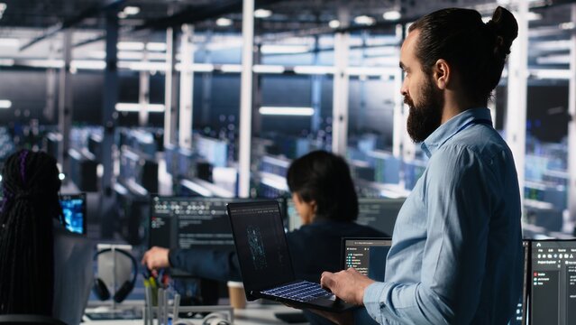 Server room technician using AI LLM chatbot to review infrastructure diagnostics. IT expert in data center using artificial intelligence large language model to analyze performance data, camera A - Powered by Adobe