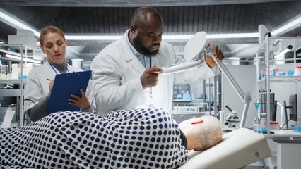 Fototapeta premium Professionals use magnifying glass to perform examination in a drug trial with patient, monitoring vitals and analyzing reactions. Studying dosage safety for biomedicine and toxicology. Camera A.