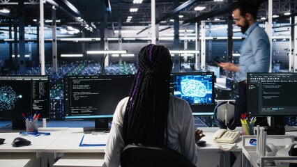 Female programmer in data center reviews AI diagnostics, analyzing neural network performance. Server hub IT expert optimizes artificial intelligence systems configuration, camera A