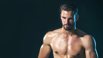 Fototapeta premium Handsome sexy young man with stylish haircut. Perfect body and skin. Athletic man with naked torso. Confident attractive man with strong muscular body. Male fitness model. Copy space for advertising.