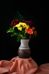 Still life of flower arrangement in vase on orange gingham check cloth © Chris Lawrence