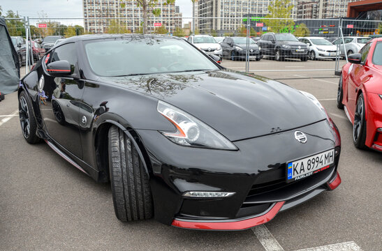 Black Nissan 370Z, a two door sports coupe, sleek design features a long hood, a sloped roofline, and muscular fenders