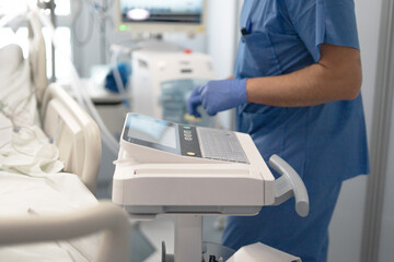 Nurse monitoring medical equipment in hospital icu unit