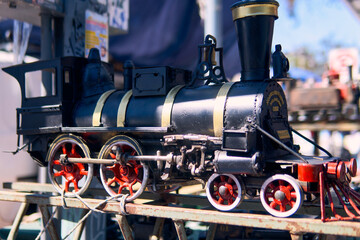Obraz premium View of a colorful, well-maintained, handcrafted locomotive. For decoration or souvenirs. Made from recyclable materials. In a public place, with natural light.