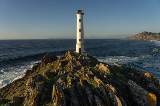 Cabo (cape) Home lighthouse on the cliffs at sunset in Rias Baixas zone in Galicia coast.
