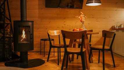 Cozy cabin interior with fireplace, dining table, and warm lighting