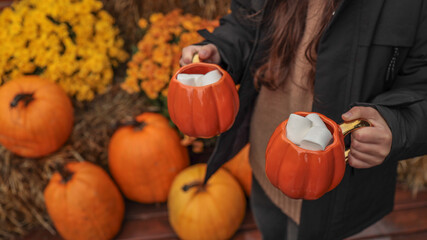 Cozy autumn scene with pumpkin mugs filled with marshmallows