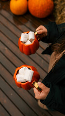 Cozy autumn scene with pumpkin mugs filled with marshmallows