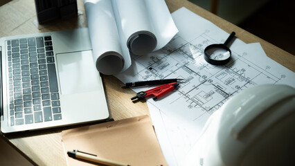 A laptop is on a table with a pair of red pens, a pair of blue pens, a pair of scissors, a pair of pliers, a pair of calipers, a pair of drafting pencils, a pair of drafting compasses,