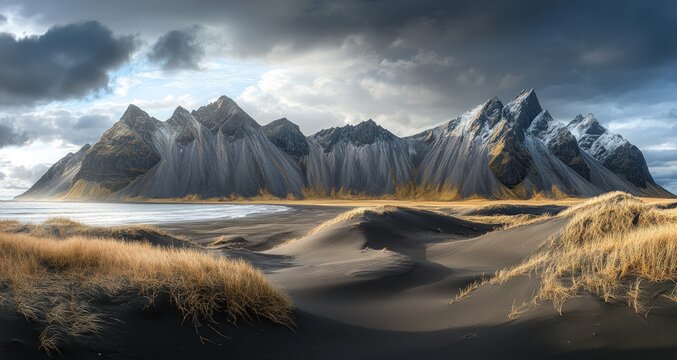 Dramatic mountain vista with black sand dunes under stormy sky
