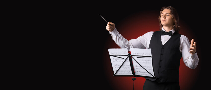 Male conductor with note sheets on dark red background