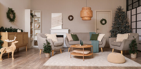 Christmas wreaths, armchair and sofa in interior of living room