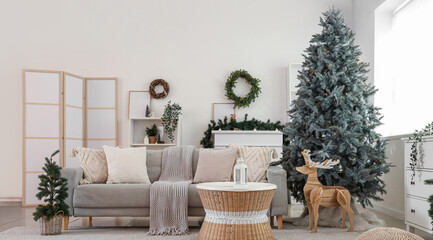 Beautiful Christmas tree, sofa and table in interior of living room